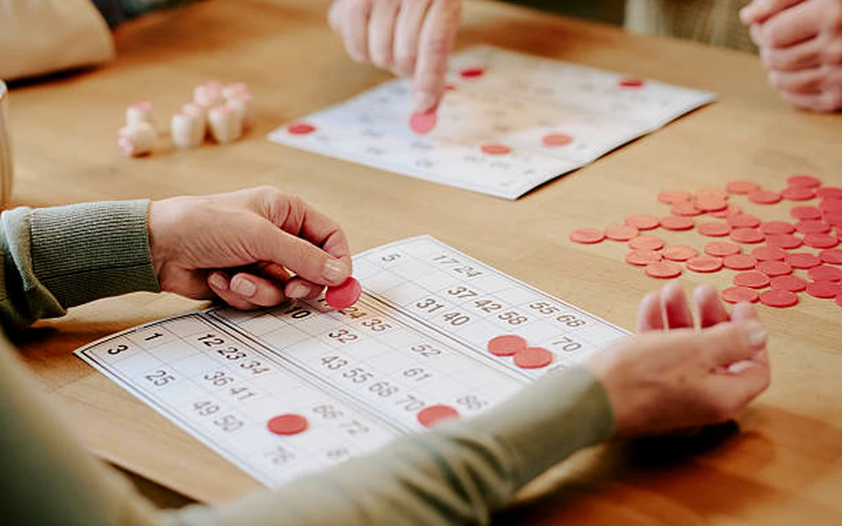 Personas jugando al bingo en una mesa durante una actividad de team building